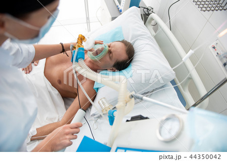 Male patient receiving mechanical ventilation in intensive care ward Male patient receiving mechanical ventilation in intensive care ward 44350042