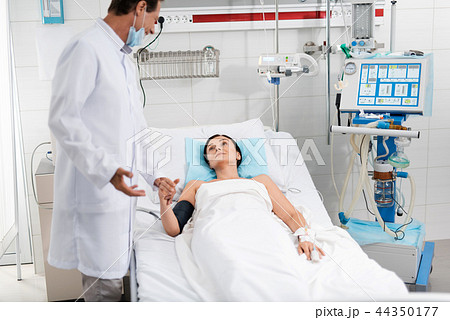 Doctor holding hand of young female patient Doctor holding hand of young female patient 44350177