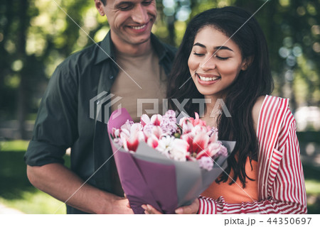 Young woman feeling happy while looking at the bouquet 44350697