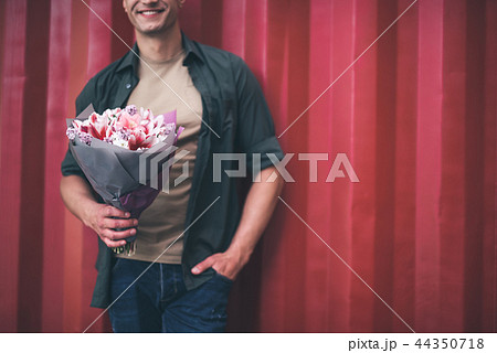 Handsome man feeling confident while standing with nice flowers 44350718