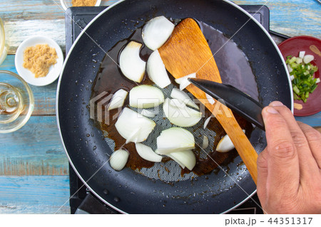 Chef frying Onion in a pan 44351317