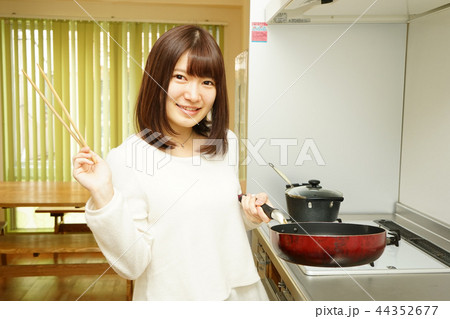 キッチンで料理をする若い女性 44352677