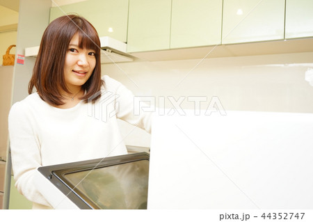 キッチンで料理をする若い女性 キッチンで料理をする若い女性 44352747