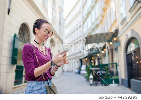 Woman talk by her smartphone in city. Young attractive tourist outdoors in italian city 44359295