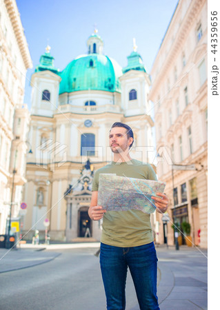 Man tourist with a city map and backpack in Europe street. Caucasian boy looking with map of Man tourist with a city map and backpack in Europe street. Caucasian boy looking with map of 44359656