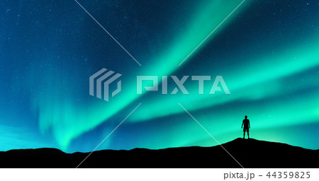 Aurora and silhouette of alone man on the hill 44359825