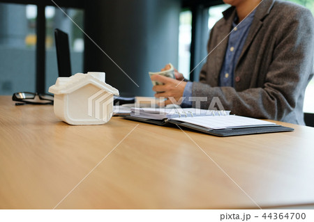 real estate agent realtor with house model & dollar banknote. buying selling renting property 44364700