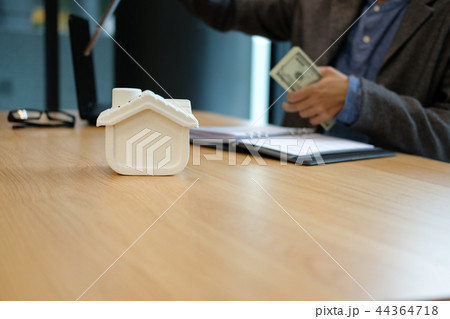 real estate agent realtor with house model & dollar banknote. buying selling renting property 44364718