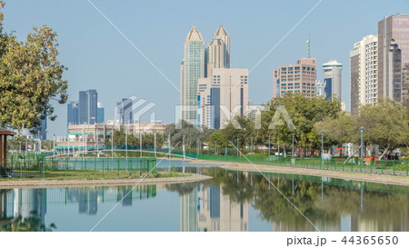 Corniche boulevard beach park along the coastline in Abu Dhabi timelapse with skyscrapers on background. Corniche boulevard beach park along the coastline in Abu Dhabi timelapse with skyscrapers on background. 44365650