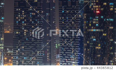 Window of the multi-storey skyscrapers of glass and steel office lighting and people within timelapse Window of the multi-storey skyscrapers of glass and steel office lighting and people within timelapse 44365812