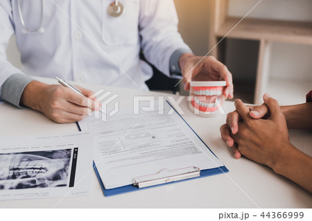 Asian male dentist hand holding pen write patient 44366999