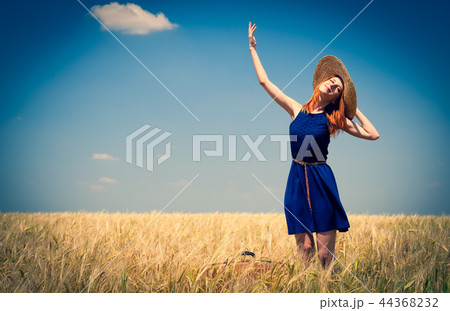 Redhead girl at spring wheat field. Redhead girl at spring wheat field. 44368232