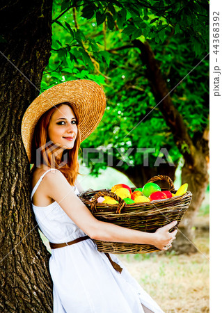 Beautiful redhead girl with fruits in basket 44368392