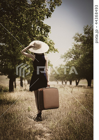 Lonely girl with suitcase at countryside. 44368493
