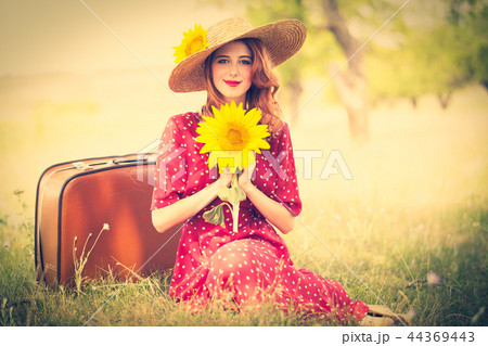 Redhead girl with sunflower at outdoor. Redhead girl with sunflower at outdoor. 44369443