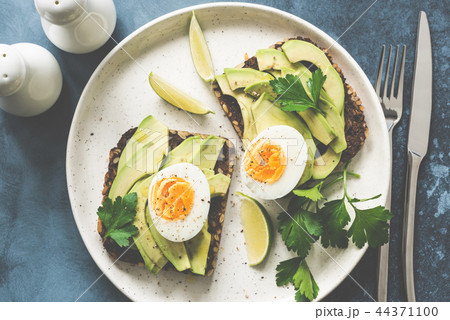 Healthy avocado toasts with boiled egg on a plate Healthy avocado toasts with boiled egg on a plate 44371100