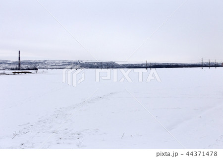 Fresh snow blankets a rural field is after a snow storm. 44371478