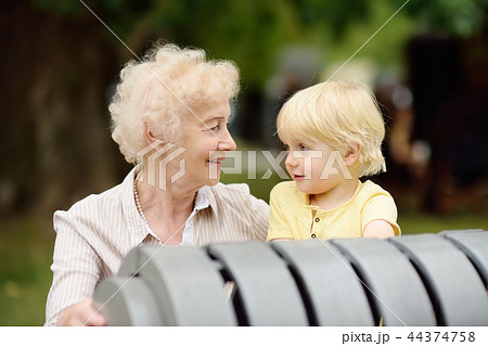 Beautiful granny and her little grandchild together in park Beautiful granny and her little grandchild together in park 44374758