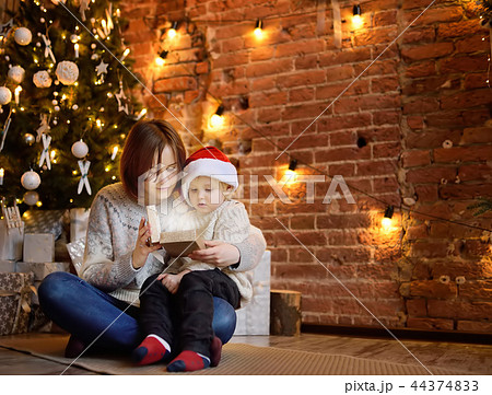 Mother with her little son reading a magic book in cozy living room. Family time on holidays 44374833