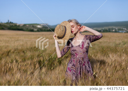 a woman farmer in field of wheat before the harvest 44375721