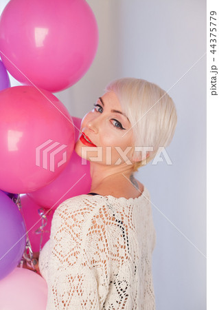 blonde woman with balloons and gifts for holiday 44375779