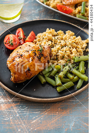 Grilled chicken thighs with bulgur, asparagus beans and tomatoes. Delicious lunch. Copy space. 44380434