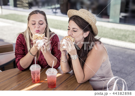Nice plump women eating unhealthy junk food Nice plump women eating unhealthy junk food 44382898