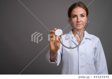 Young beautiful woman doctor against gray background 44383949