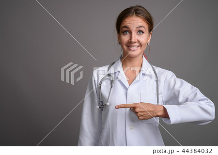 Young beautiful woman doctor against gray background 44384032