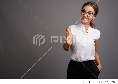 Young beautiful businesswoman against gray background 44384190