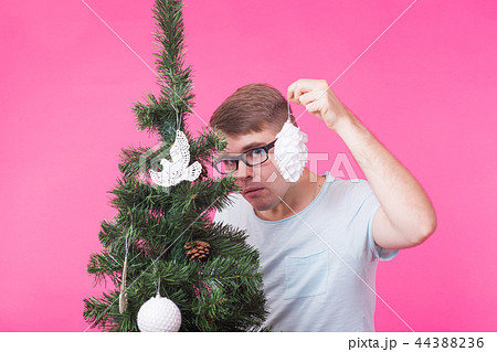 Christmas, holidays and people concept - young happy man show christmas decorations on christmas 44388236