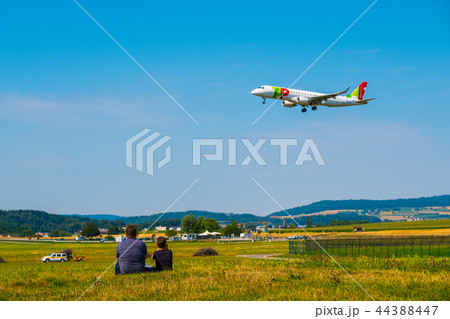 Father and son watching landing airplanes at Zurich airport at sunny day time Father and son watching landing airplanes at Zurich airport at sunny day time 44388447