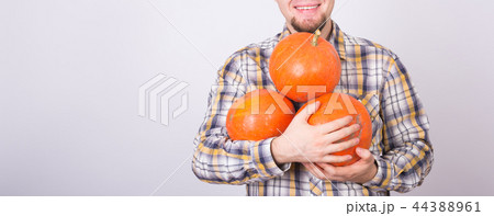 Close up of male farmer with pumpkins smiling over the white background with copy space 44388961