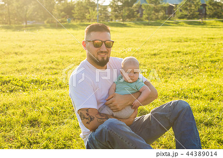 Happy father holding baby son on nature. Concept of happy family, father's day and child. 44389014
