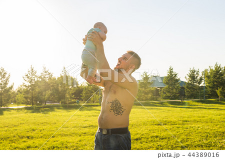 Happy father holding baby son, throwing baby in air. Concept of happy family, father's day and child 44389016