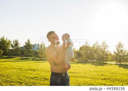Happy father holding baby son on nature. Concept of happy family, father's day and child. 44389136