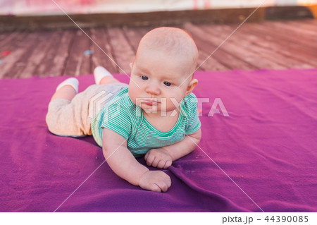 Cute child baby boy lying on blanket in summer day on nature. Family picnic in a park. Cute child baby boy lying on blanket in summer day on nature. Family picnic in a park. 44390085
