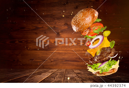 Big tasty burger with flying ingredients. Big tasty burger with flying ingredients. 44392374
