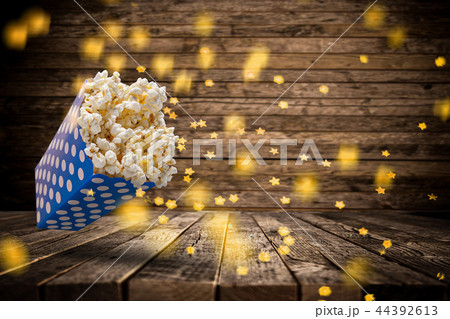 Popcorn explosion on old wooden table. Popcorn explosion on old wooden table. 44392613