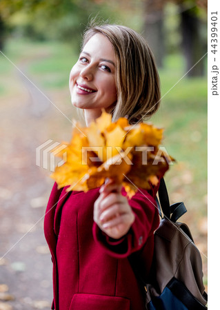 Young style girl with leaves in park alley Young style girl with leaves in park alley 44399401