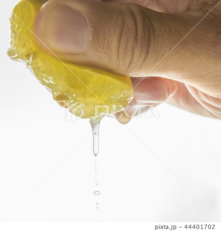 Human hand squeezing half of lemon 44401702