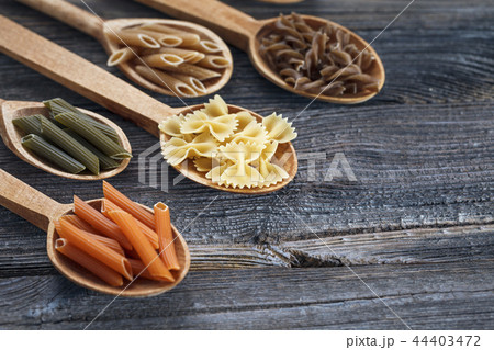 A set of raw pastas on spoons on a wooden table A set of raw pastas on spoons on a wooden table 44403472
