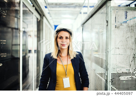 A portrait of an industrial woman engineer standing in a factory. 44405097
