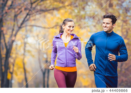 Man and woman running as fitness sport in an autumn park 44409866