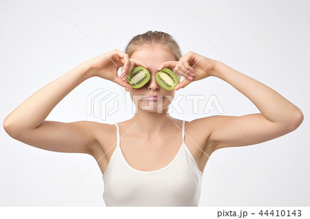Kiwi. Healthy fruit funny woman holding kiwi fruit for her eyes. Kiwi. Healthy fruit funny woman holding kiwi fruit for her eyes. 44410143