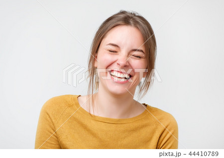 Beautiful young woman in yellow sweater laughing 44410789