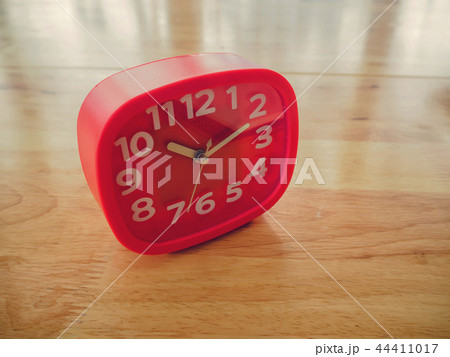 Red rectangle alarm clock on wooden table Red rectangle alarm clock on wooden table 44411017