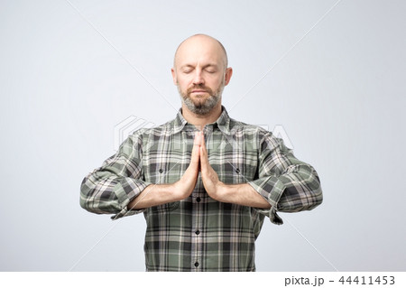 Yoga and meditation concept. Handsome bald man with bristle keeping eyes closed while meditating 44411453