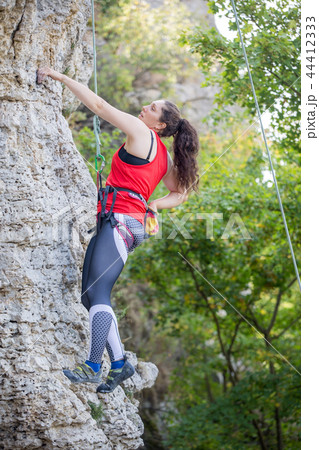 Photo of athlete girl clambering over rock 44412333