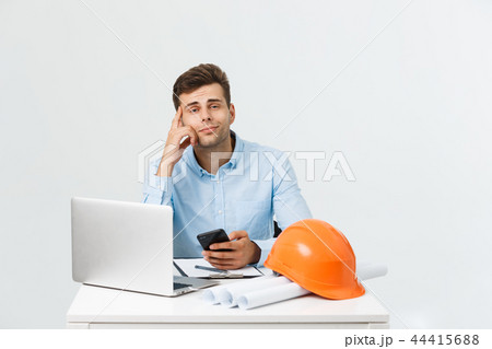 Happy young construction workers in hard hats on a white background. Happy young construction workers in hard hats on a white background. 44415688